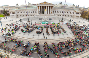 Demonstration von System Change, not Climate Change in Wien während der Klimakonferenz COP21. Aktivist*innen formen die Worte "System Change".